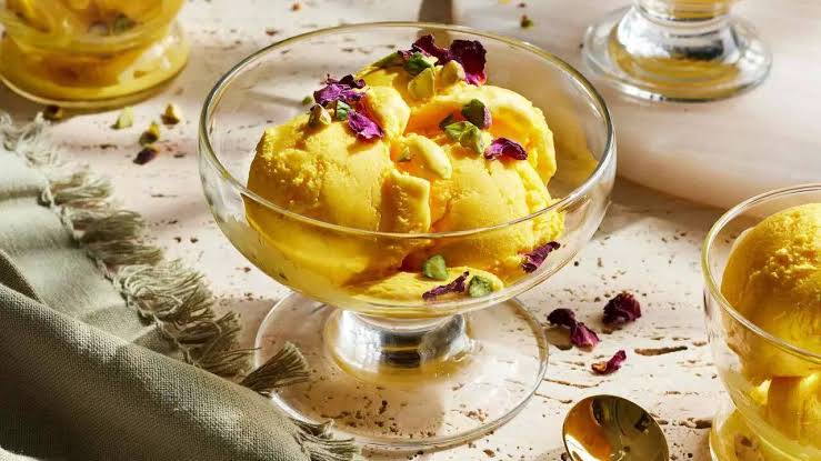 Saffron ice cream garnished with pistachios and rose petals
